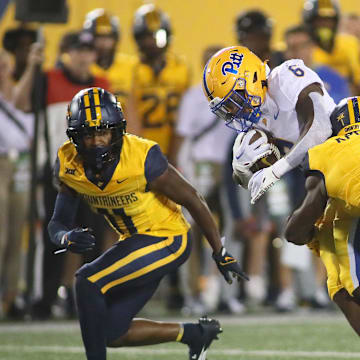 Pittsburgh Panthers Rodney Hammond Jr. (6) gets wrapped up for a tackle by West Virginia Mountaineers Beanie Bishop Jr. (11) and Lee Kpogba (1) during the first half at Milan Puskar Stadium in Morgantown, WV on September 16, 2023.