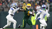 Green Bay Packers running back Josh Jacobs (8) stiff-arms Detroit Lions safety Kerby Joseph during last year's game at Lambeau Field.