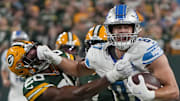 One of the Detroit Lions' young stars, tight end Sam LaPorta (87) stiff-arms former Packers safety Rudy Ford in 2023.