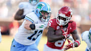 Oklahoma Sooners wide receiver Deion Burks tries to escape Tulane Green Wave linebacker Tyler Grubbs.