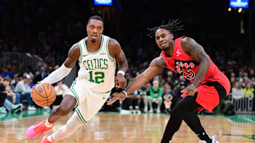 Oct 13, 2024; Boston, Massachusetts, USA;  Boston Celtics guard Lonnie Walker IV (12) controls the ball while Toronto Raptors guard Davion Mitchell (45) defends during the first half at TD Garden. Mandatory Credit: Bob DeChiara-Imagn Images