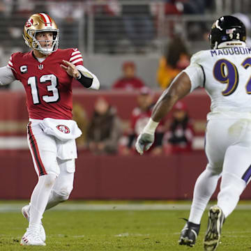 San Francisco 49ers quarterback Brock Purdy throws a pass next to Baltimore Ravens defensive tackle Nnamdi Madubuike.