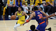 May 27, 2025; Indianapolis, Indiana, USA; Indiana Pacers guard Tyrese Haliburton (0) drives to the hoop past New York Knicks center Karl-Anthony Towns (32) during the fourth quarter of game four of the eastern conference finals for the 2025 NBA Playoffs at Gainbridge Fieldhouse. Mandatory Credit: Trevor Ruszkowski-Imagn Images