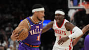 Mar 30, 2025; Phoenix, Arizona, USA; Phoenix Suns guard Devin Booker (1) drives on Houston Rockets guard Aaron Holiday (0) in the first half at Footprint Center. Mandatory Credit: Rick Scuteri-Imagn Images