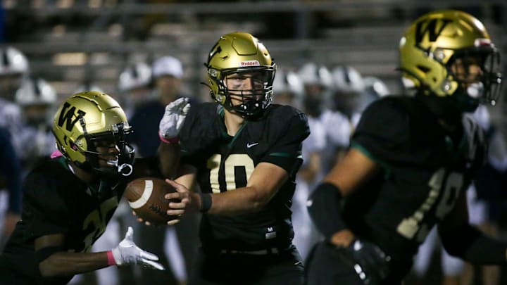 Iowa City West’s quarterback Jack Wallace (10) hands the ball off to Butali Butali (35) while playing Pleasant Valley Friday, Oct. 18, 2024 in Iowa City, Iowa. Iowa City West’s quarterback Jack Wallace (10) hands the ball off to Butali Butali (35) while playing Pleasant Valley Friday, Oct. 18, 2024 in Iowa City, Iowa.