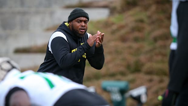 Oregon offensive line coach A'lique Terry leads a workout during spring practice with the Ducks in Eugene, Oregon