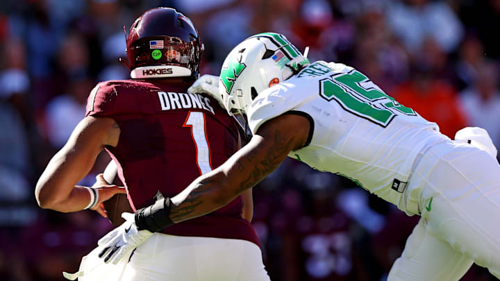 Marshall Thundering Herd defensive lineman Mike Green sacks Virginia Tech Hokies quarterback Kyron Drones. Marshall Thundering Herd defensive lineman Mike Green sacks Virginia Tech Hokies quarterback Kyron Drones.