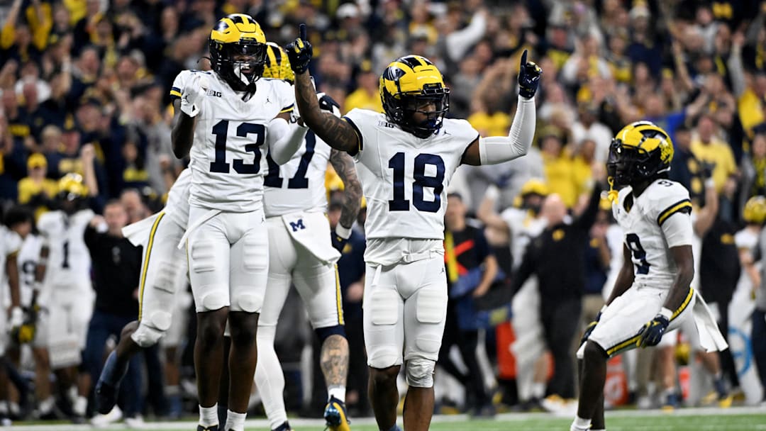 Dec 2, 2023; Indianapolis, IN, USA; Michigan Wolverines defensive back Ja'Den McBurrows (18) and defensive back DJ Waller Jr. (13) celebrate after a turnover during the second half of the Big Ten Championship game against the Iowa Hawkeyes at Lucas Oil Stadium. Mandatory Credit: Robert Goddin-Imagn Images