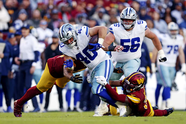 Dallas Cowboys running back Hunter Luepke (runs the ball against Washington Commanders safety Percy Butler 