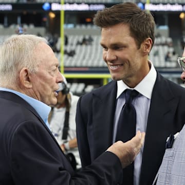 Dallas Cowboys owner Jerry Jones, FOX Sports' Tom Brady, and Cowboys CEO Stephen Jones talk on the field before a game.