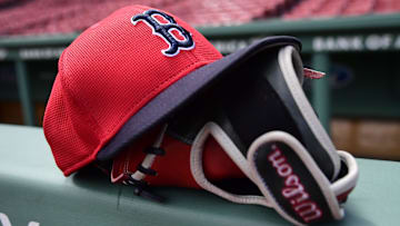 May 18, 2025; Boston, Massachusetts, USA;  A Boston Red Sox hat and glove rests on the railing by the dugout prior to a game against the Atlanta Braves at Fenway Park. Mandatory Credit: Bob DeChiara-Imagn Images