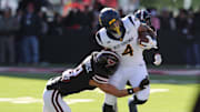 Nov 30, 2024; Lubbock, Texas, USA;  Texas Tech Red Raiders defensive back CJ Baskerville (9) tackles West Virginia Mountaineers running back CJ Donaldson Jr. (4) in the first half at Jones AT&T Stadium and Cody Campbell Field. Mandatory Credit: Michael C. Johnson-Imagn Images