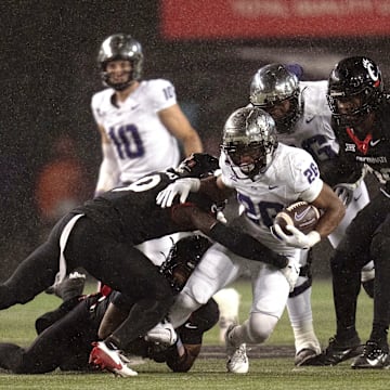 Nov 30, 2024; Cincinnati, Ohio, USA; TCU Horned Frogs running back Jeremy Payne (26) is tackled by Cincinnati Bearcats linebacker Jiquan Sanks (9) in the third quarter at Nippert Stadium. Mandatory Credit: Albert Cesare/USA TODAY Network via Imagn Images