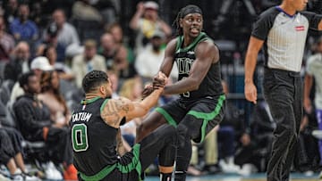 Boston Celtics guard Jrue Holiday (4) helps forward Jayson Tatum (0) onto his feet after a foul late during the second half against the Charlotte Hornets at the Spectrum Center.