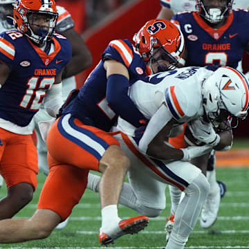 Syracuse Orange linebacker Justin Barron tackles Virginia Cavaliers wide receiver Keytaon Thompson.