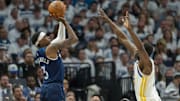 May 8, 2025; Minneapolis, Minnesota, USA; Minnesota Timberwolves forward Jaden McDaniels (3) shoots the ball over Golden State Warriors forward Draymond Green (23) in the second half during game two of the second round for the 2025 NBA Playoffs at Target Center.