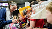 Indiana Fever guard Caitlin Clark signs autographs for fans after the Fever defeated Brazil in a preseason game.