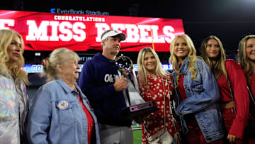 Mississippi Rebels head coach Lane Kiffin, center left, poses with the Ash Verlander Champions Trophy with his family after the game of the TaxSlayer Gator Bowl.