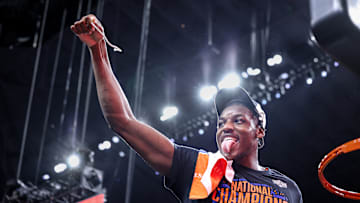 Center Rueben Chinyelu cuts down part of the net after the Florida Gators' win over Houston in the national championship.