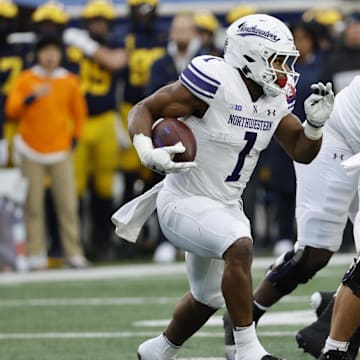 Nov 23, 2024; Ann Arbor, Michigan, USA;  Northwestern Wildcats running back Cam Porter (1) runs the ball against the Michigan Wolverines in the first half at Michigan Stadium. Mandatory Credit: Rick Osentoski-Imagn Images