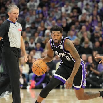 Dec 26, 2024; Sacramento, California, USA; Sacramento Kings guard Malik Monk (0) controls the ball against Detroit Pistons guard Jaden Ivey (23) during the fourth quarter at Golden 1 Center. Mandatory Credit: Kelley L Cox-Imagn Images