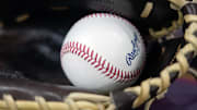 A baseball sits in a glove before a 2025 MLB game.