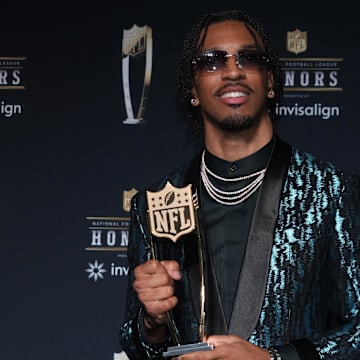 Washington Commanders quarterback Jayden Daniels poses with the Offensive Rookie of the Year award.
