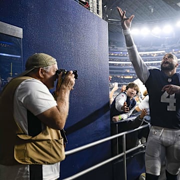 Dallas Cowboys QB Dak Prescott tosses his hat to the fans as he walks off the field after the game between the Cowboys and the New York Giants.