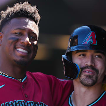 Sep 18, 2024; Denver, Colorado, USA; Arizona Diamondbacks outfielder Corbin Carroll (7) (right) celebrates his solo home run with shortstop Geraldo Perdomo (2) (left) in the first inning against the Colorado Rockies at Coors Field. Mandatory Credit: Ron Chenoy-Imagn Images