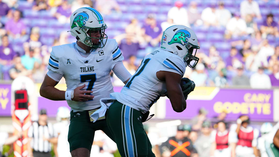 Nov 4, 2023; Greenville, North Carolina, USA; Tulane Green Wave quarterback Michael Pratt (7) hands the ball off to running back Makhi Hughes (21) against the East Carolina Pirates during the first half at Dowdy-Ficklen Stadium. Nov 4, 2023; Greenville, North Carolina, USA; Tulane Green Wave quarterback Michael Pratt (7) hands the ball off to running back Makhi Hughes (21) against the East Carolina Pirates during the first half at Dowdy-Ficklen Stadium.